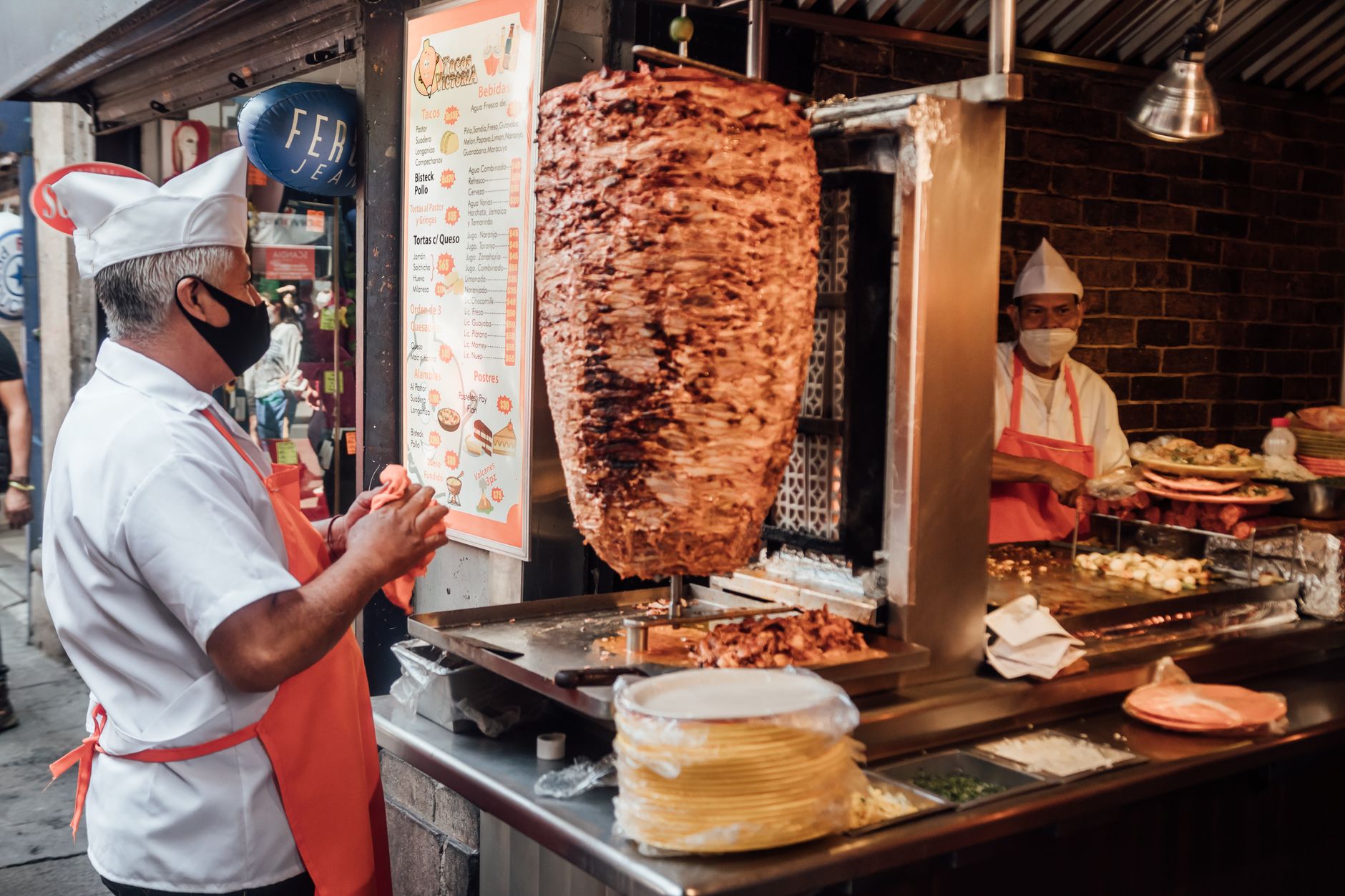 Tacos sizzling on a street-food grill at night